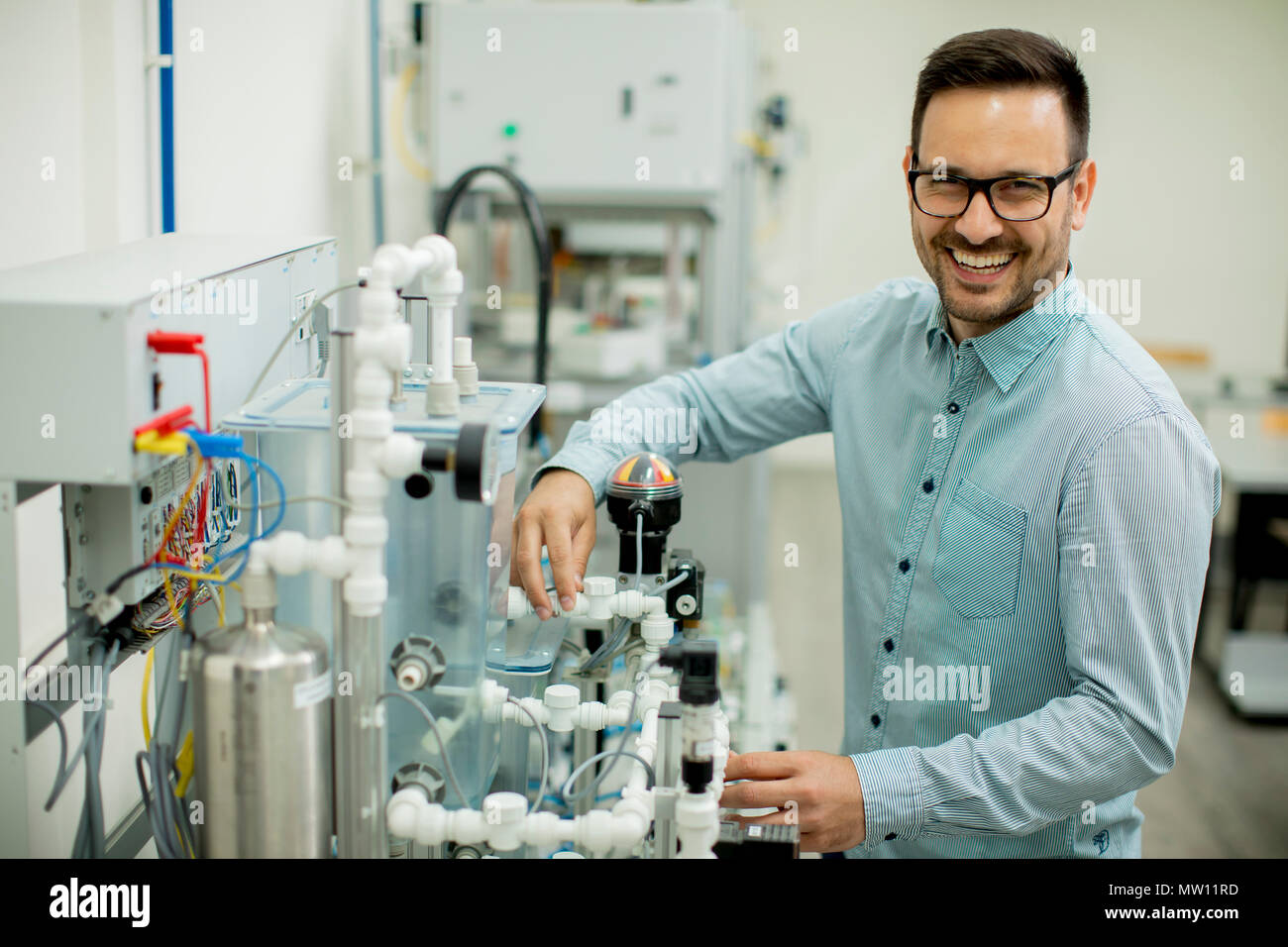 Hübscher junger Mann, der in der elektronischen Werkstatt Stockfoto