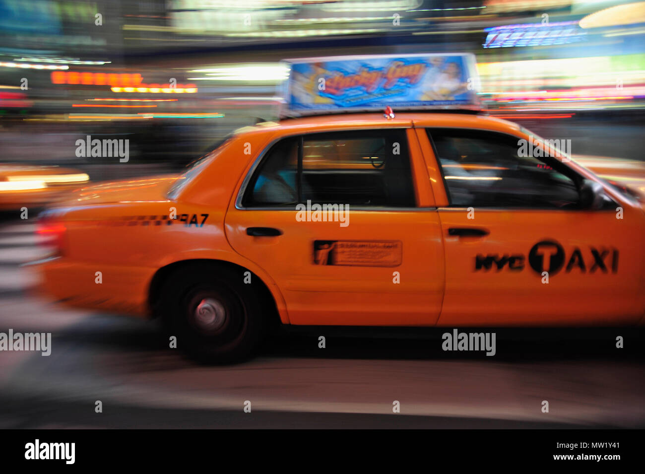New York Taxi bewegen durch den Times Square, mit Kunden und Fahrer sichtbar und Unschärfe der Lichter jenseits, New York, NY, USA Stockfoto