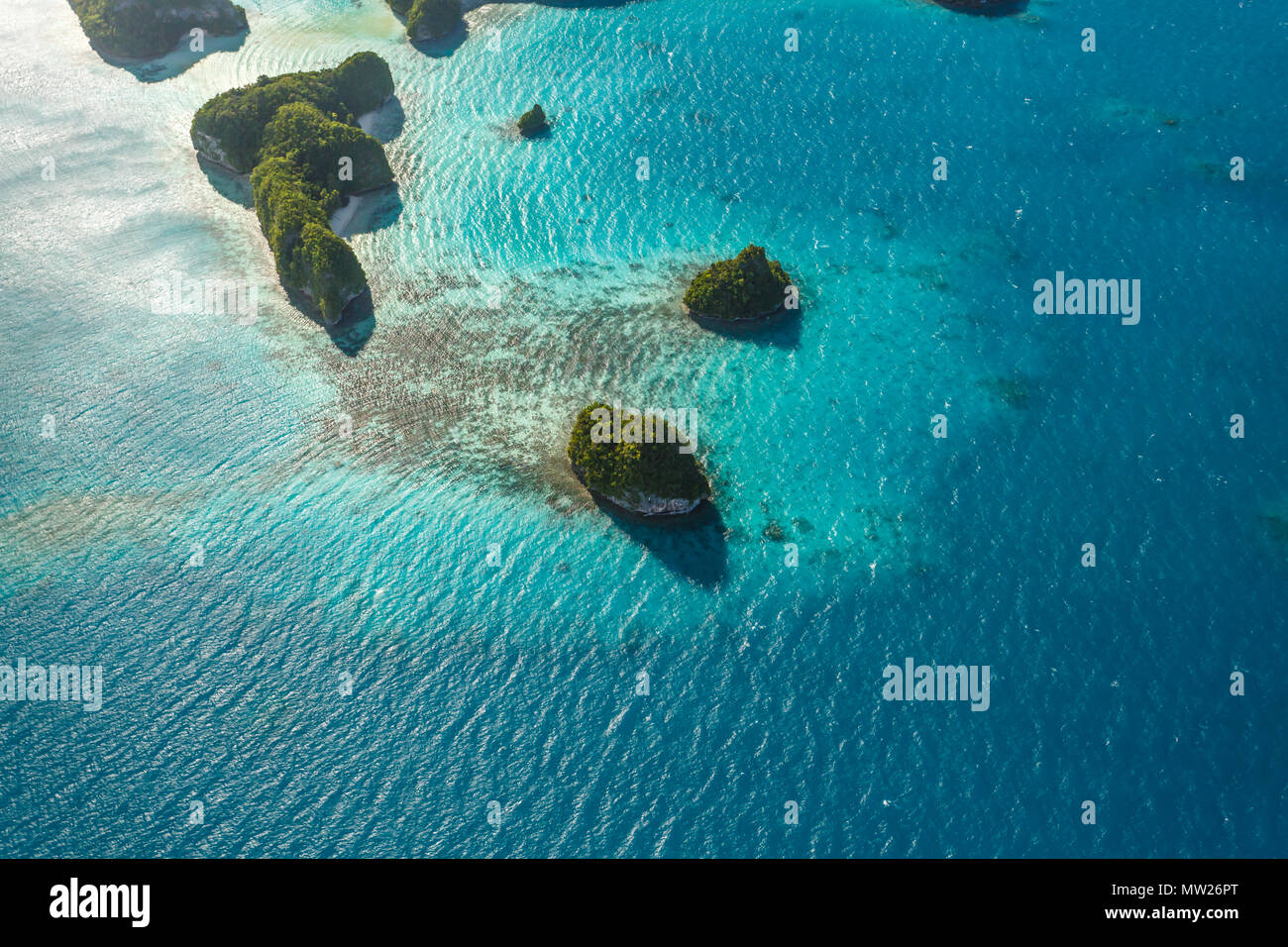 Luftaufnahme von neugierig mustern der Korallenriffe, coral Atolle und Inseln umgeben vom türkisblauen Wasser des Südpazifik Stockfoto
