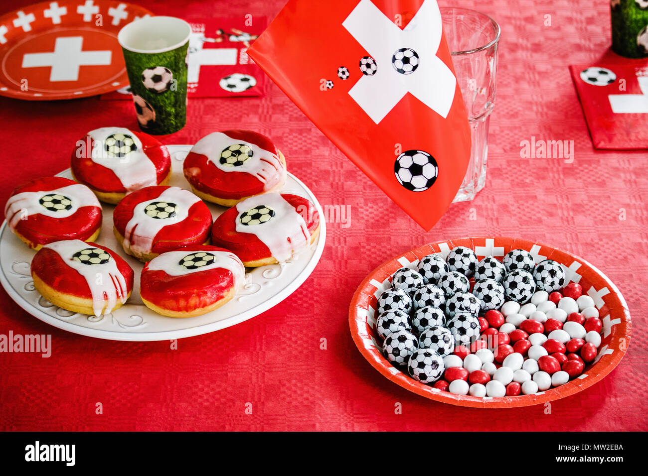 Donuts und Schokolade Süßigkeiten wie kleine Fußbälle auf rotem Tuch  geprägt. Fußball-Party zu Hause. Schweizer Flagge, Fußball Fieber in der  Schweiz Stockfotografie - Alamy