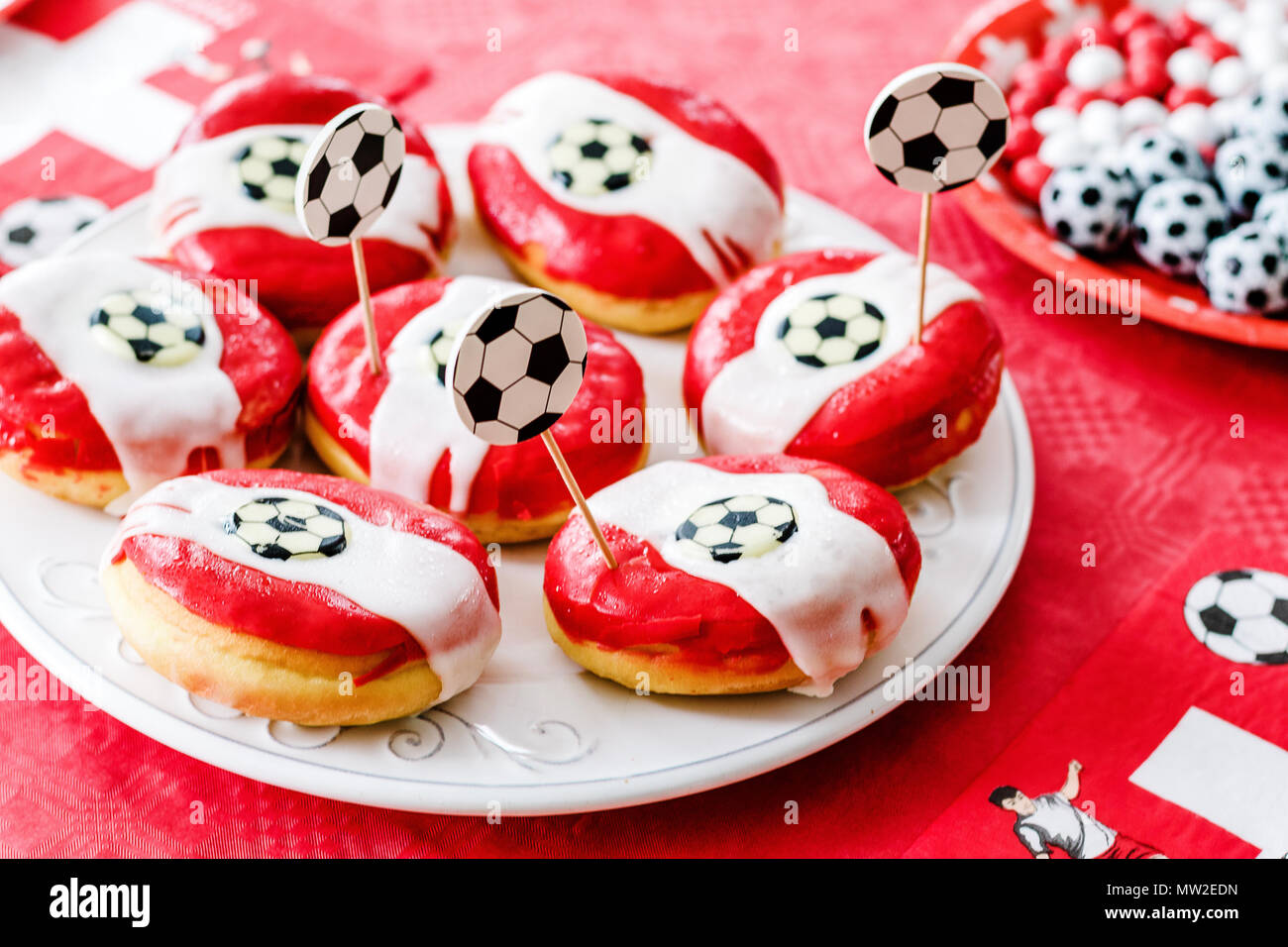 Donuts und Schokolade Süßigkeiten wie kleine Fußbälle auf rotem Tuch  geprägt. Fußball-Party zu Hause. Schweizer Flagge, Fußball Fieber in der  Schweiz Stockfotografie - Alamy