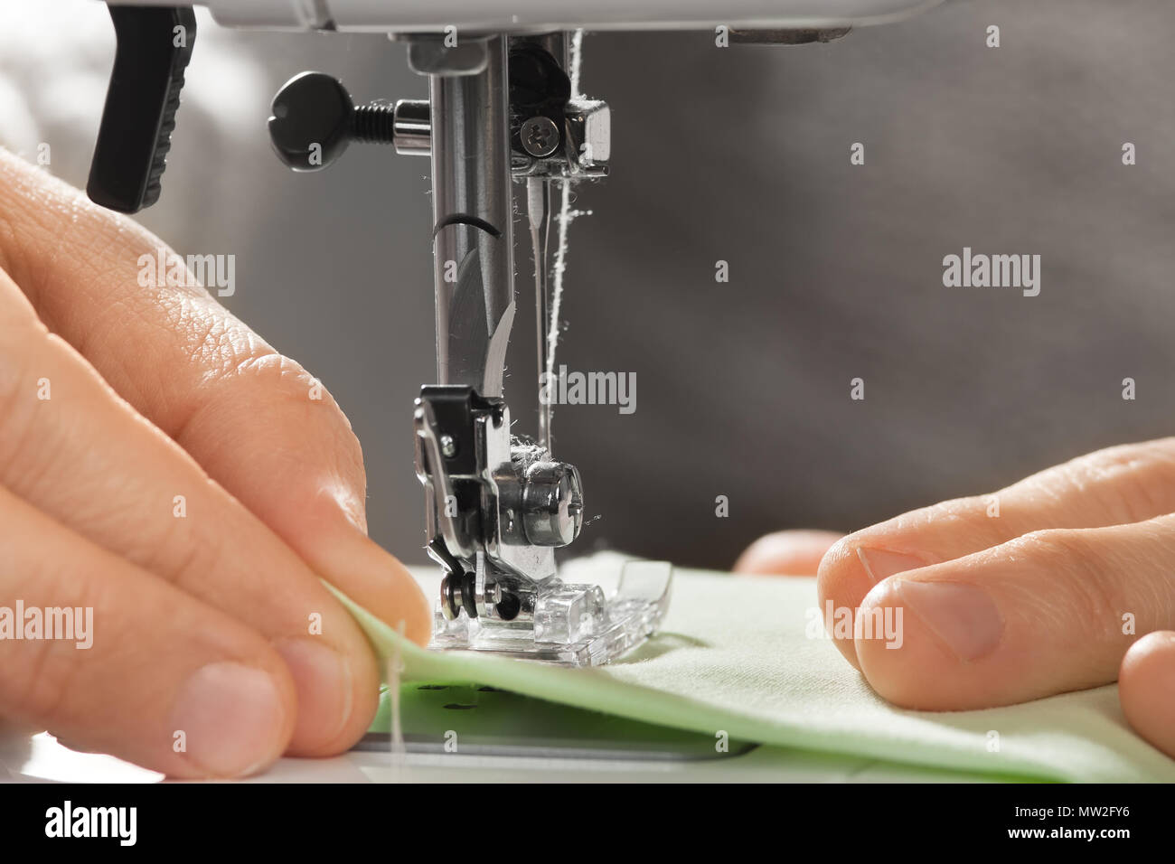 Hände der Näherin arbeiten an der Nähmaschine, Nahaufnahme Stockfoto