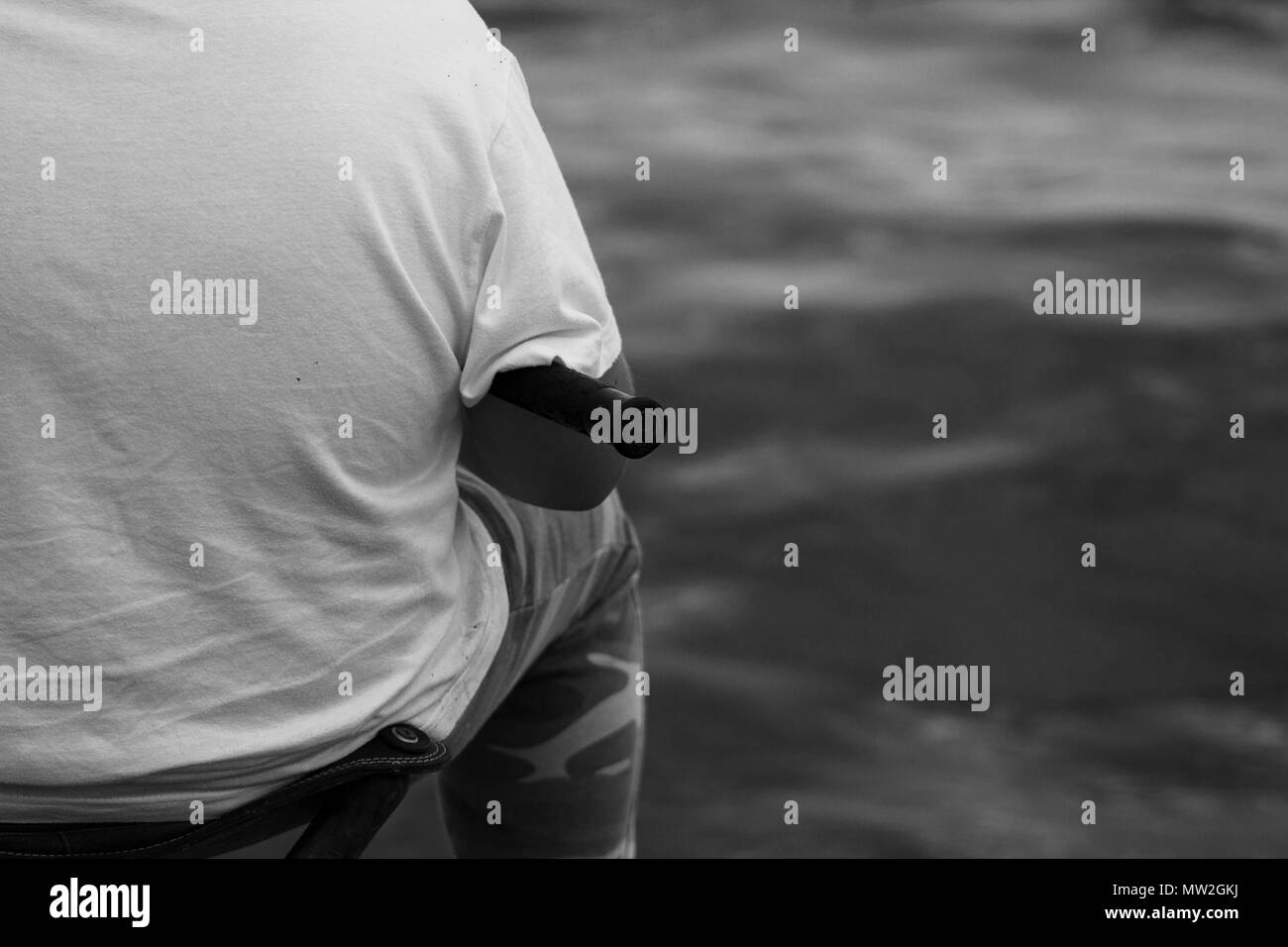 Schwarz und weiß Fischer an Bord Kai mit Angelrute Stockfoto