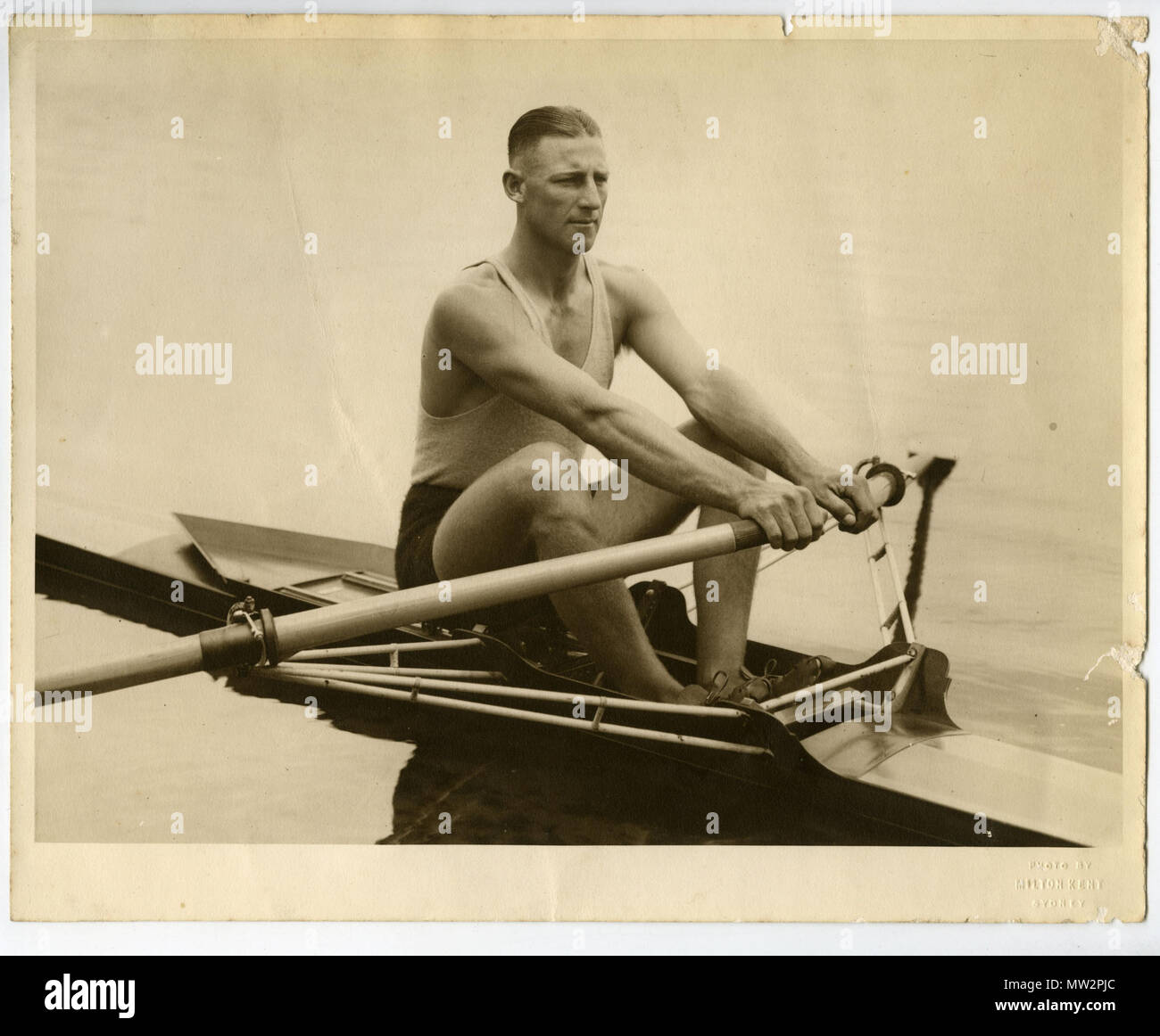 . Diese schwarz-weiß Foto von Henry Robert "Bobby" Pearce (1905-1976) wurde von Milton Kent in Sydney. Pearce war die erste australische zu einer Goldmedaille im Einzel sculls. Später im Jahre 1928 trat er in den renommierten Henley Diamond Sculls, wurde aber als nicht zuschussfähig eingestuft, weil er ein Tischler durch Handel war. Der Henley rennen Regeln als jedermann untauglich zu konkurrieren, war "durch Handel oder Beschäftigung für Löhne ein Mechaniker, Handwerker oder Arbeiter". Er ging auf die einzelnen Sculls an den British Empire Games 1930 in Hamilton, Ontario. Während der Depression, Pearce Schwierigkeiten hatten, emp Stockfoto