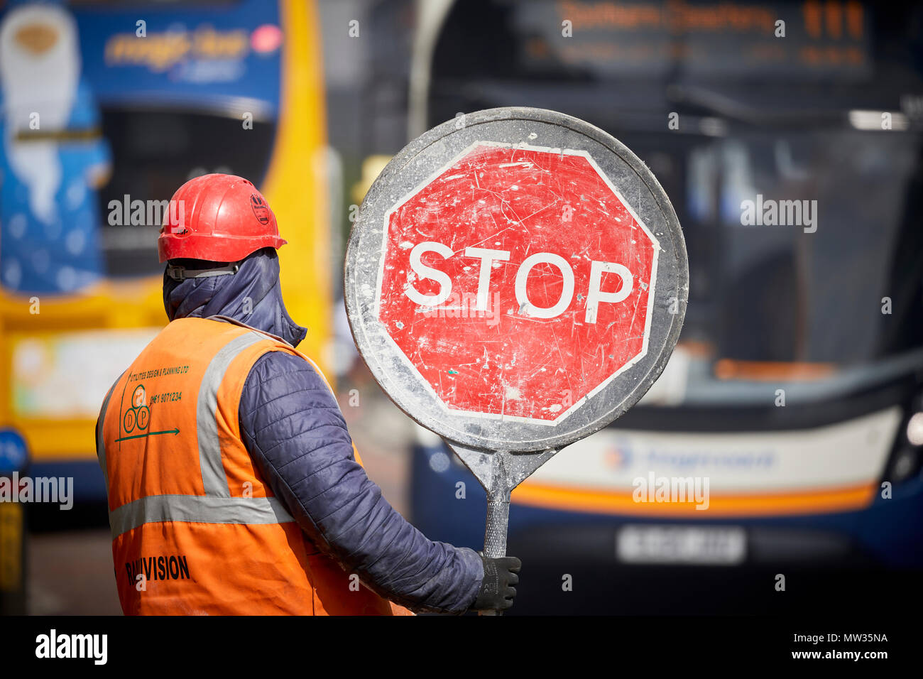 Bauarbeiter mit einer manuellen Traffic Flow Management mit einem Stop Schild der Oxford Road in Manchester. Stockfoto
