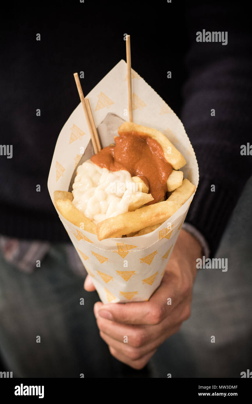 Mann mit Pommes mit Soße Stockfoto