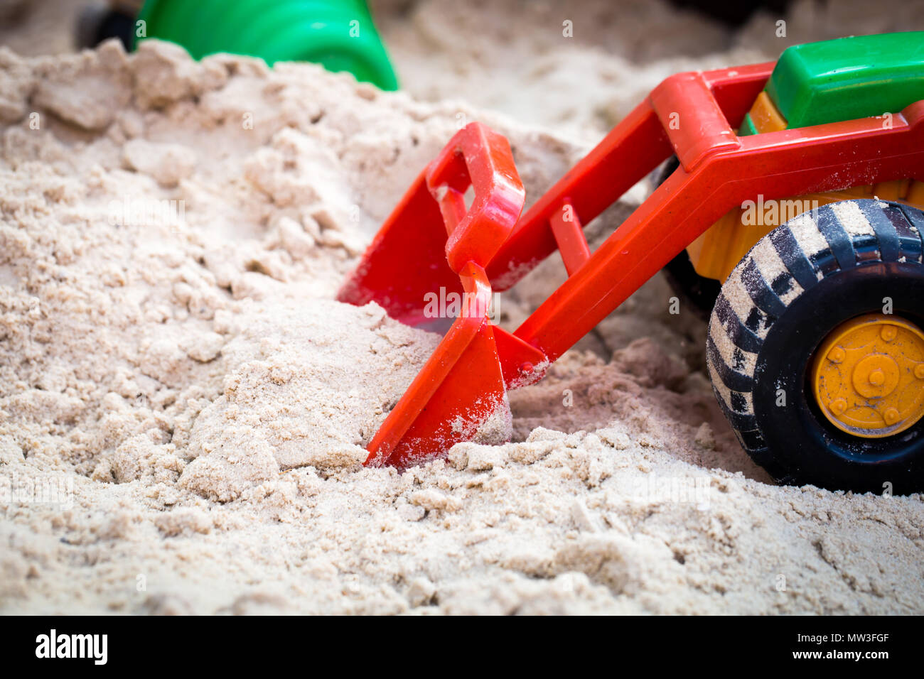 Spielzeug für Kinder im Sandkasten, die Schlepper nimmt der Sand Stockfoto