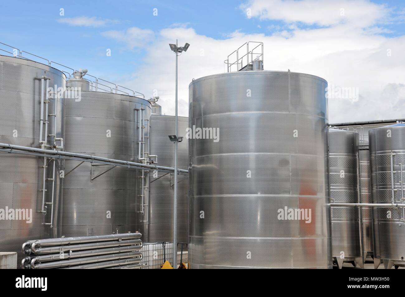 Großen Stahltanks für Wein Reifung, mit bewölktem Himmel Hintergrund, Weingut moderne Ausrüstung, Nahaufnahme, Ansicht von vorne Stockfoto