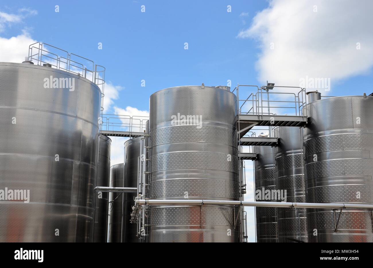 Großen Stahltanks für Wein Reifung, bewölkter Himmel Hintergrund, Weingut moderne Ausrüstung, Nahaufnahme, Ansicht von unten Stockfoto