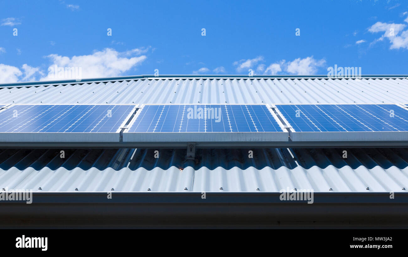 Solarzellen auf dem Dach eines Hauses auf einem hellen, sonnigen Tag. Stockfoto