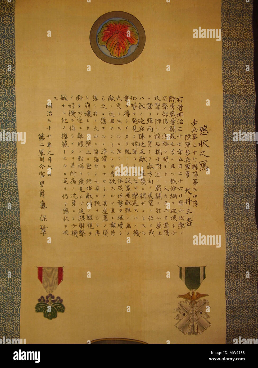 . Englisch: Porträt der Meiji- Ära japanischer Soldat, ein commemorative blättern Sie mit Ehren-Zitat in Bezug auf seine Handlungen während der Russo-japanischen Krieg (unklar, ob es sich um eine posthume-memorial Blättern oder nicht, Übersetzung erforderlich); wittig Sammlung, Malerei-05; 02, 02; obere Kante abgeschnitten, aber das Gemälde ist leer über Mons/Emblem. ca. 1905 (?). unbekannter Künstler (s), Fotografien von User: Lx 121 309 Japanese.soldier.russo-japanese.war.commemorative.scroll.with.honors.wittig.collection.painting.05.top.half.minus.top.edge.02.of.02 Stockfoto