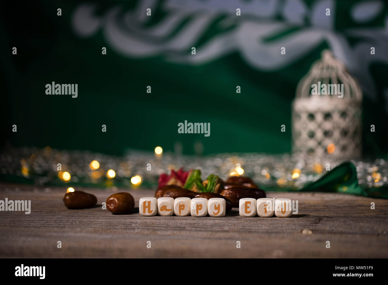Gratulation: Eid Mubarak! Arabische Süßigkeiten auf einer hölzernen  Oberfläche. Kerzenständer, Nacht Licht und Nacht blauer Himmel mit Halbmond  im Hintergrund Stockfotografie - Alamy