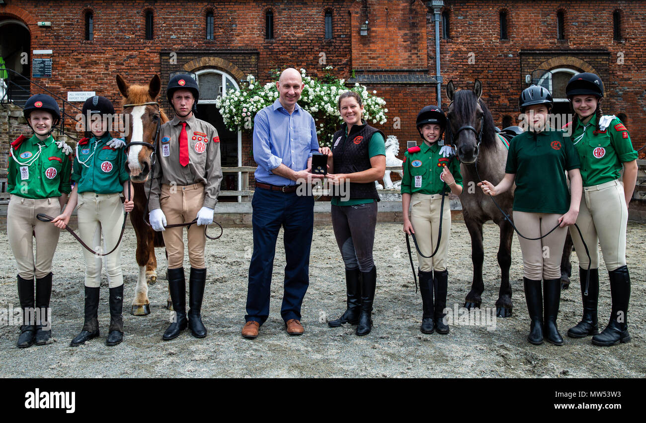 (Nach rechts) Maia Davies, Lola Doyle, Matthew Sheppard, Stephen Lee Links, Geschäftsführer von Bradford Exchange, Theresa Barrett, stabile Manager des Pferdes Förster Verband, Caitlin Aldous und Abi Evans Pose beim Starten der Gold Viertel souverän das Portrait der Königin zu Pferd von Bradford Exchange am Pferd Förster Association, Royal Mews, Surrey freigegeben. Stockfoto