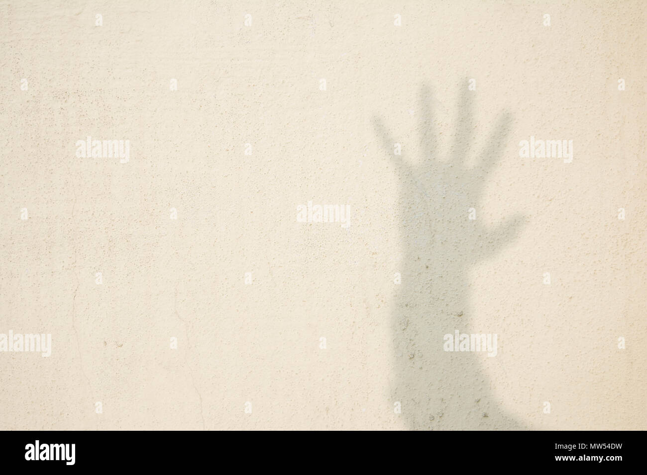 Schatten der menschlichen Hand auf abstrakte Wand Stockfoto