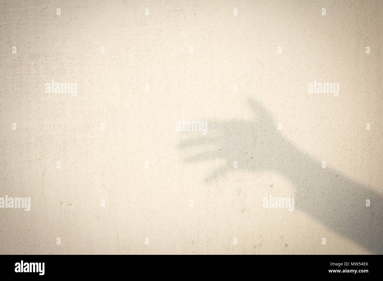 Schatten der menschlichen Hand auf abstrakte Wand Stockfoto