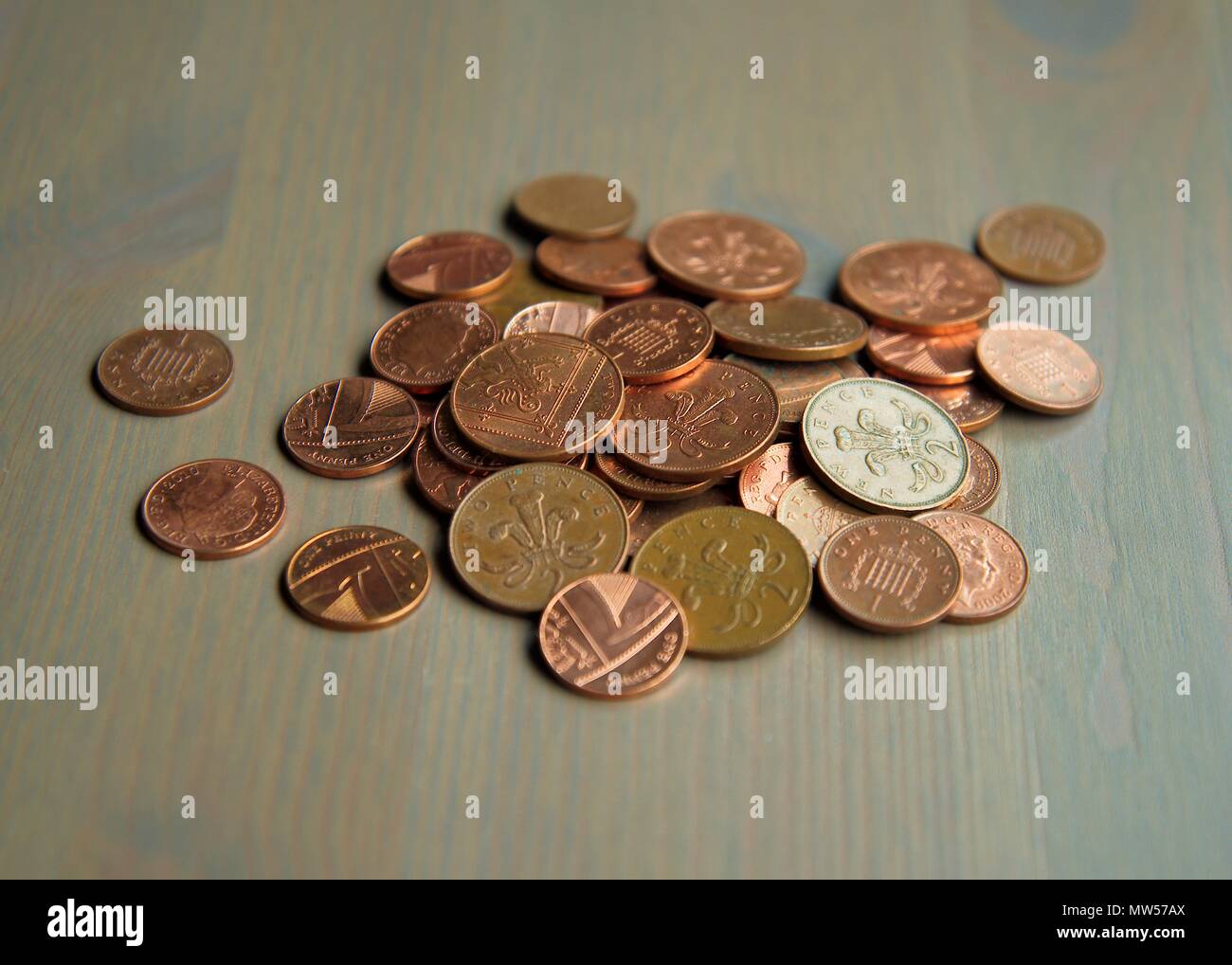 Ein Haufen von eins und zwei Penny sterling Münzen auf einer hölzernen Oberfläche verwendet. Stockfoto