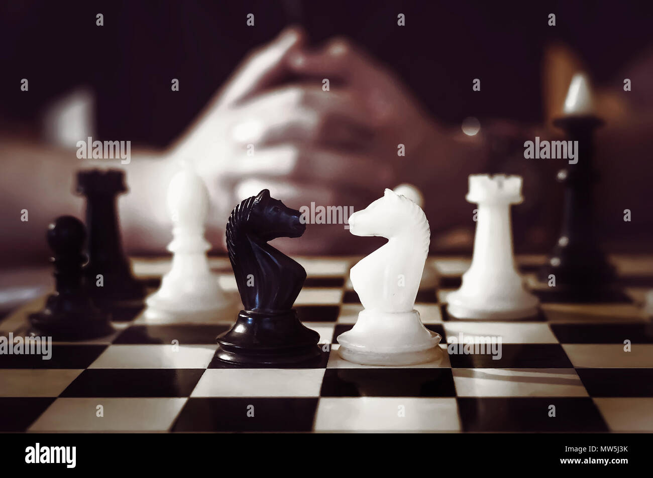 Mann spielt Schach, den Erfolg des Geistes. Die unscharfen Hand im Hintergrund gekreuzt. Stockfoto