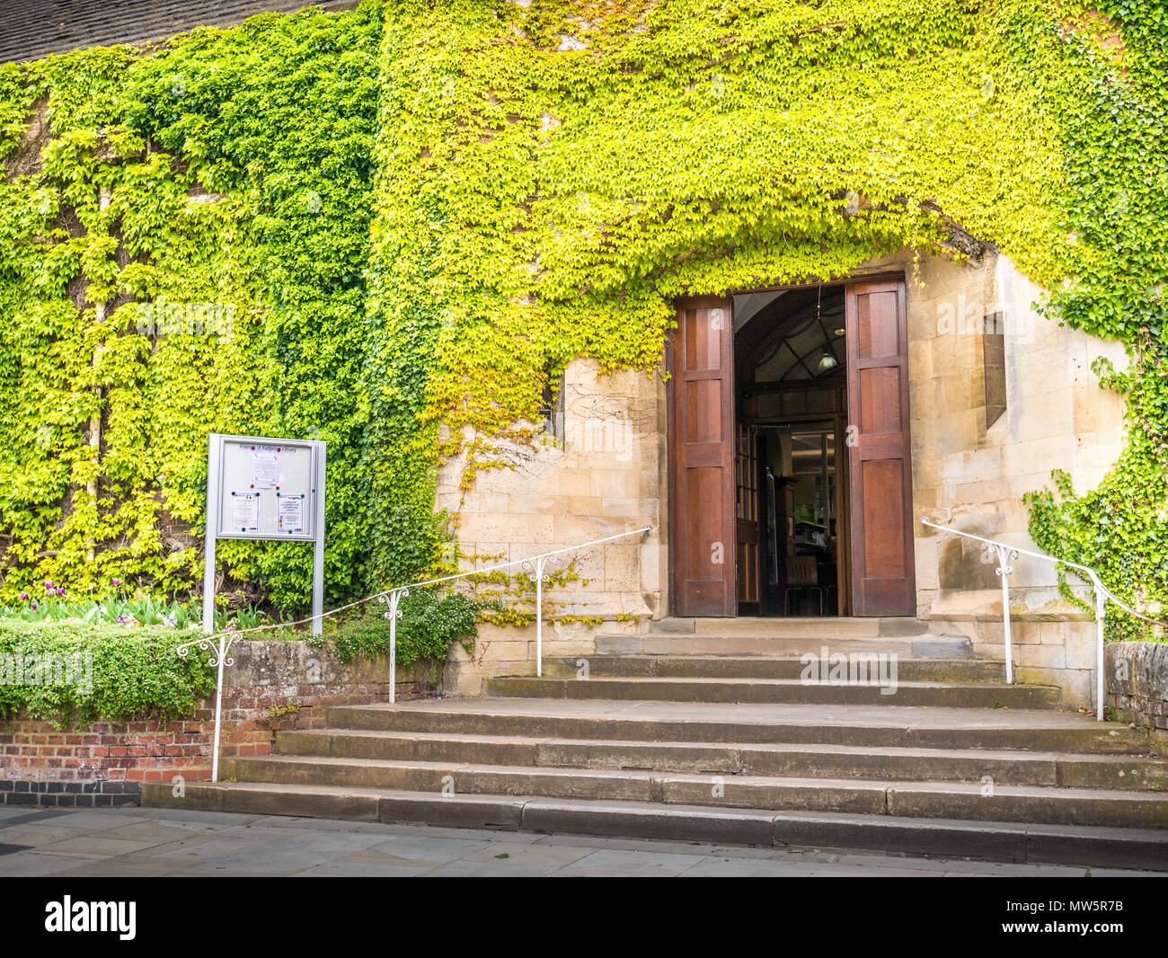 Die grüne efeubewachsene Mauer um den Eingang zur Bibliothek in der Sheep Street im Stadtzentrum von Kettering, England. Stockfoto