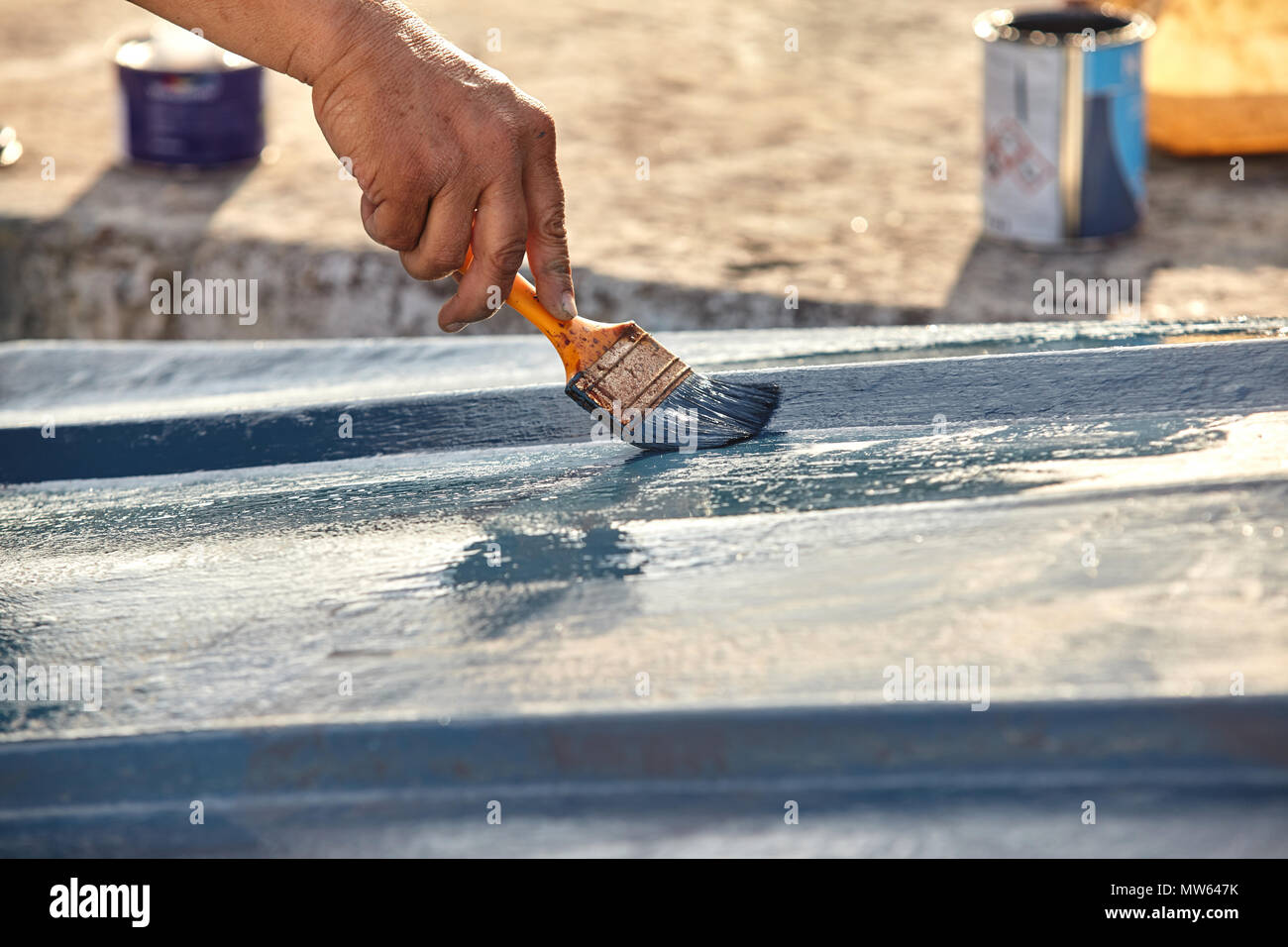 Mann Malerei Boot. Detailansicht von Hand mit einem Pinsel mit blauer Farbe. Stockfoto