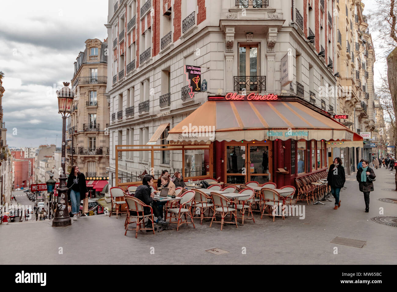 Winter in Paris, die Leute draußen sitzen Chez Ginette auf der Rue Caulaincourt, ein Café und Restaurant, Montmartre, Paris Stockfoto