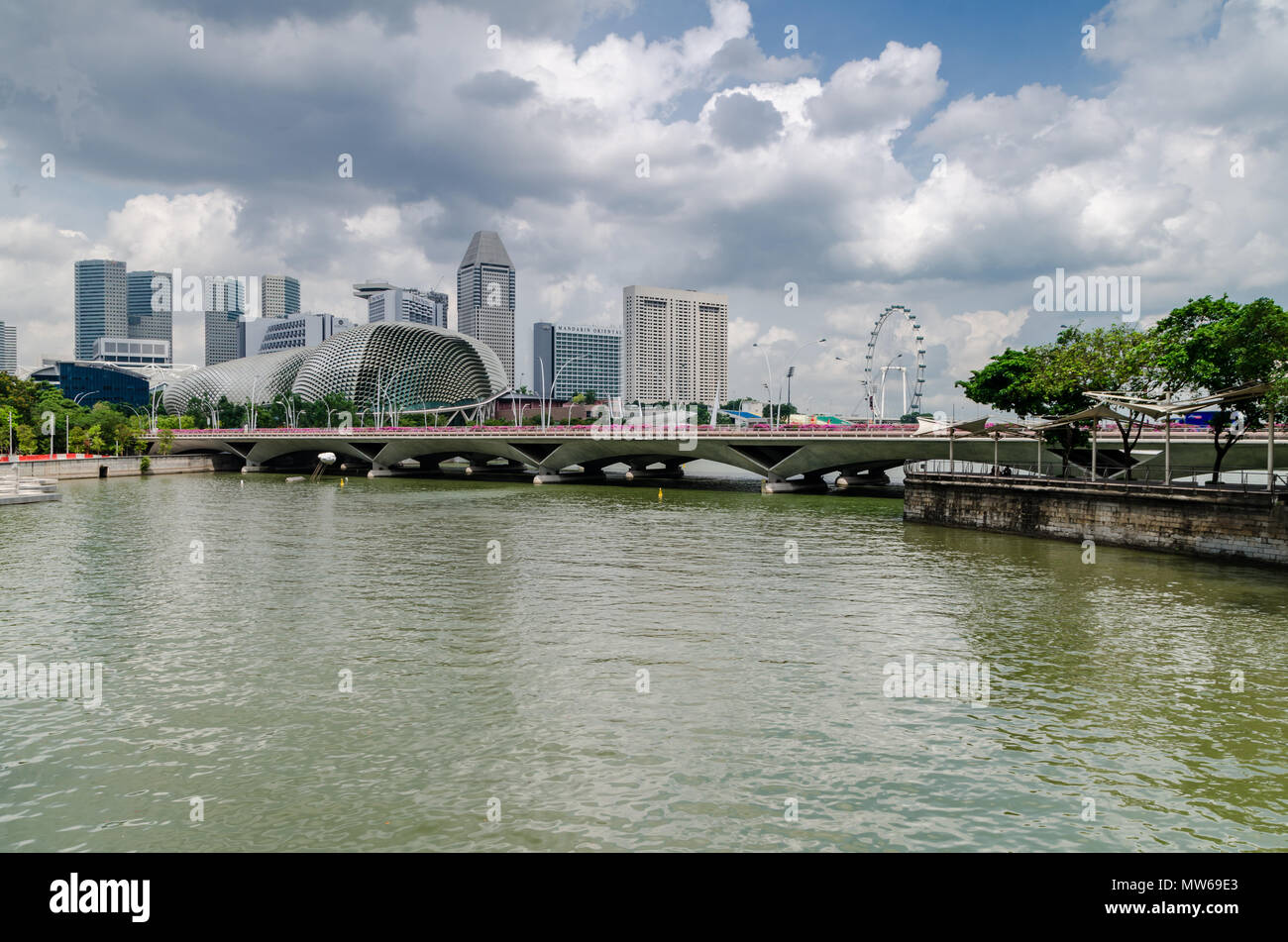 Ein Kreuzfahrtschiff, bekannt als twakows Fahrt durch die berühmten Singapore River. Das Gebäude an der Rückseite ist die berüchtigte Theater an der Bucht, Esplanade. Stockfoto