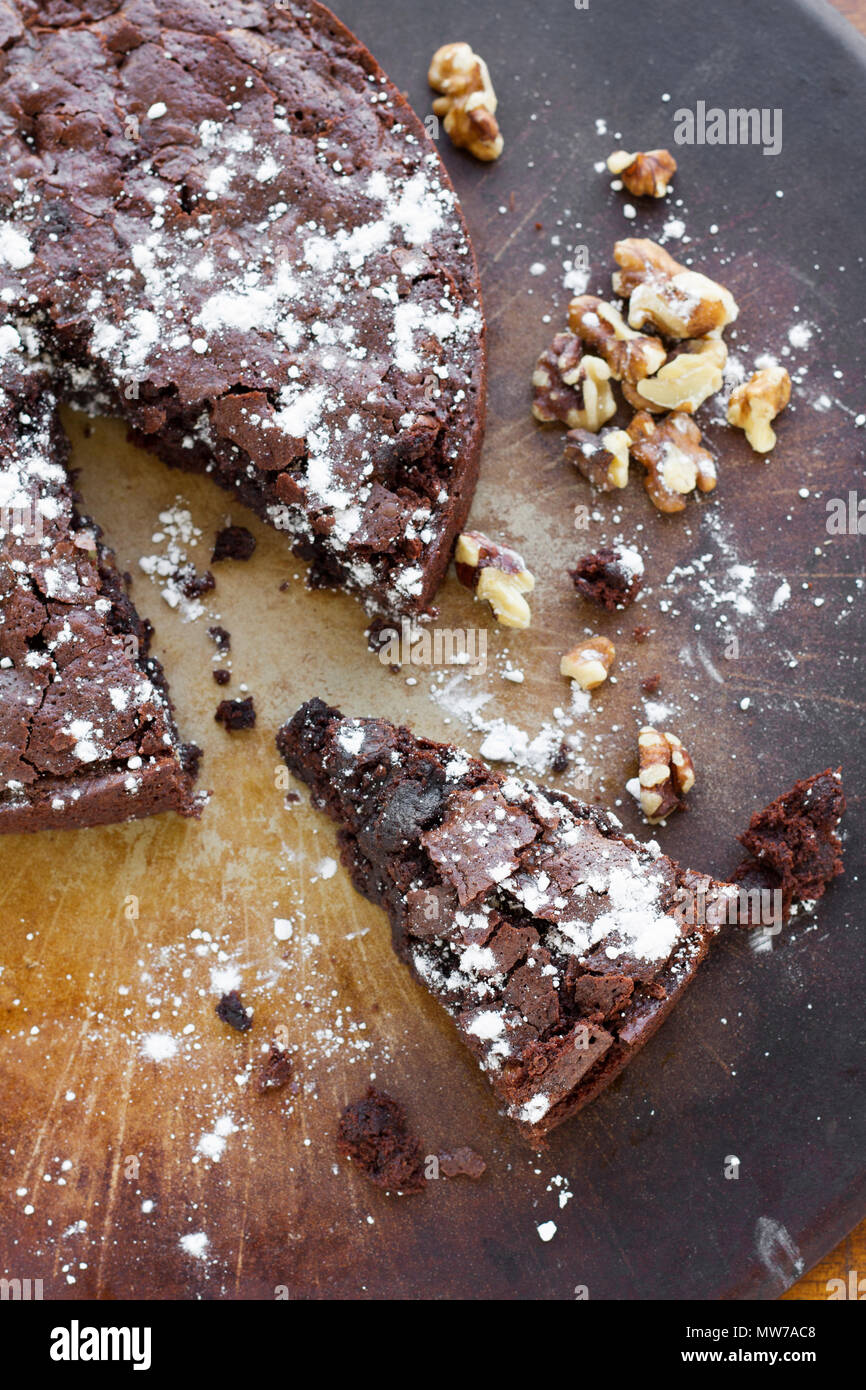 Chocolate Fudge Brownie Dessert Kuchen mit Walnüssen und Puderzucker, in Segmente zerlegt. Stockfoto