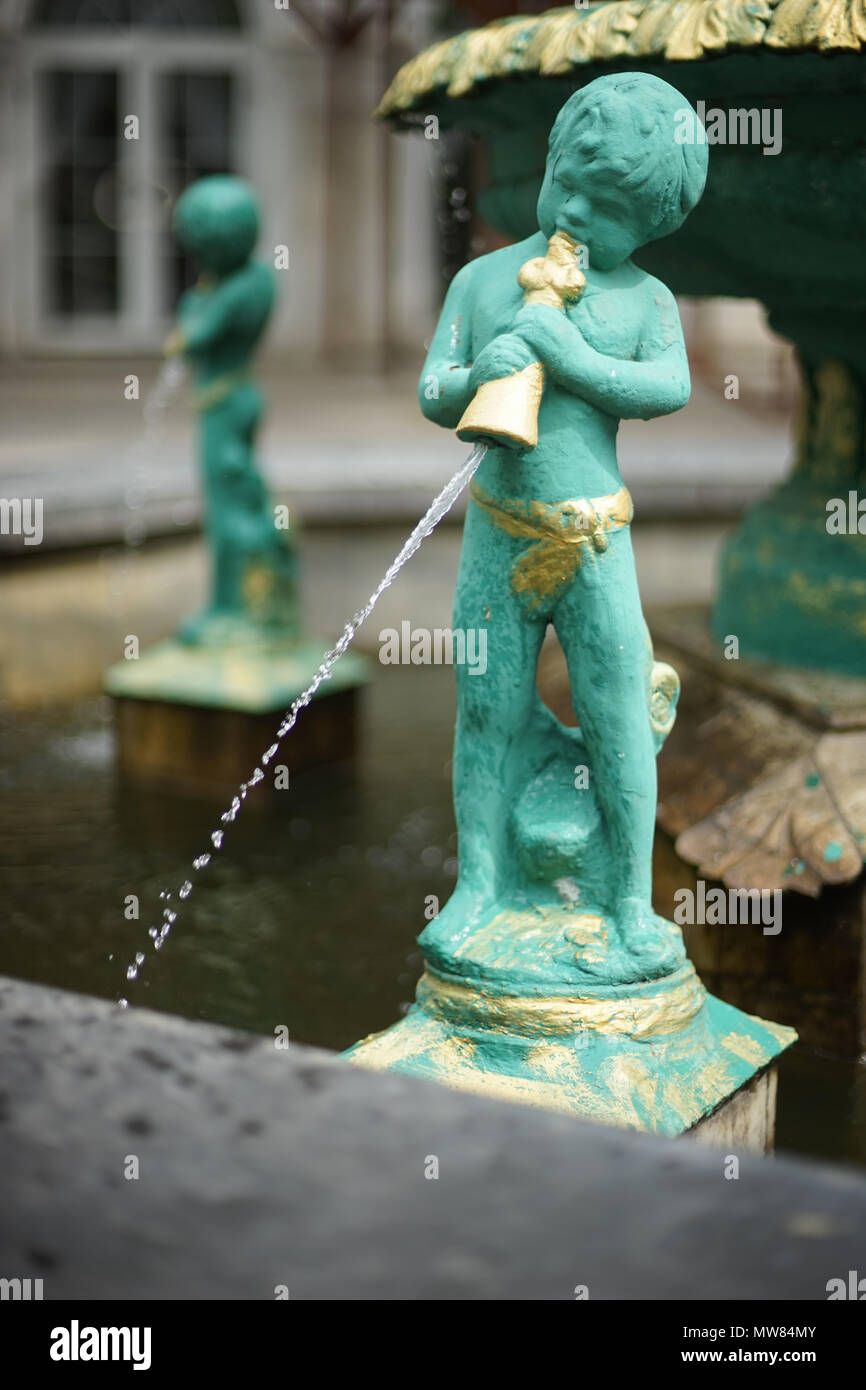 Grüne Cupid Statue, die in einem Brunnen Stockfoto