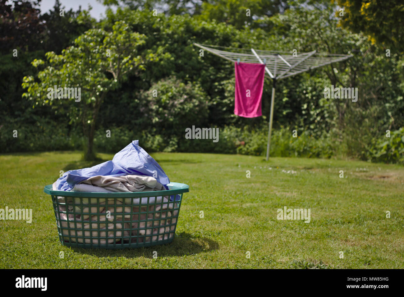 Die Hausarbeit erledigt werden muss. Ein Korb mit Wäsche wartet auf eine Wäscheleine an einem hellen Sommertag aufgehängt werden. Stockfoto