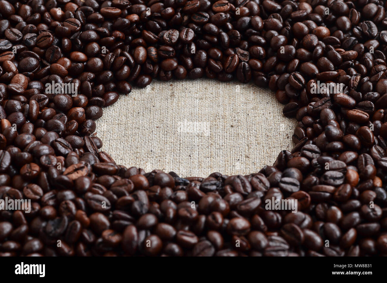 Textur eine graue Leinwand aus alten und grobes Sackleinen, auf dem sich ein bestimmter Betrag der braunen Bohnen. Blick von oben auf die Sack Hellgrau colo Stockfoto