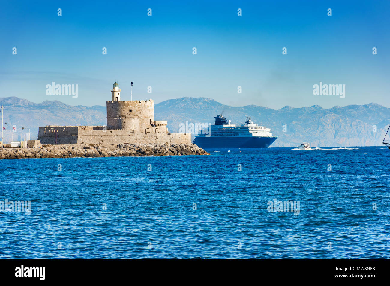 Kreuzfahrt Schiff hinter Leuchtturm in Mandraki Hafen in der Stadt Rhodes (Rhodos, Griechenland) Stockfoto