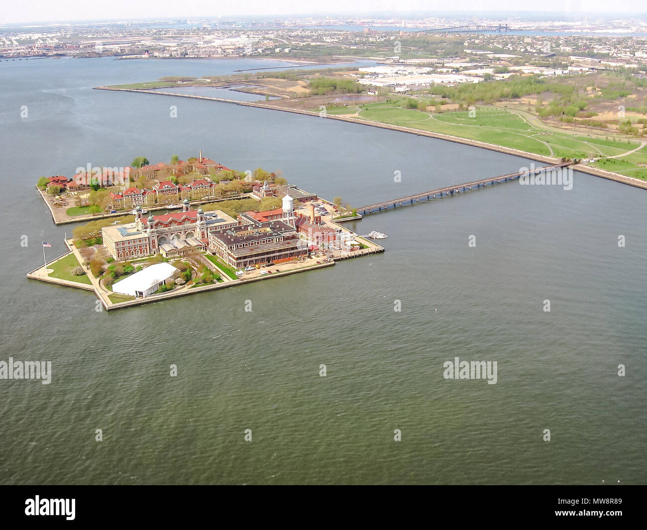 Spektakuläre Helikopterblick auf Ellis Island, eine kleine Insel an der Mündung des Hudson River in New York Harbour, über besucht das gleiche Ticket und Fähre, die Zugang zu den nahe gelegenen Freiheitsstatue ermöglicht. Stockfoto