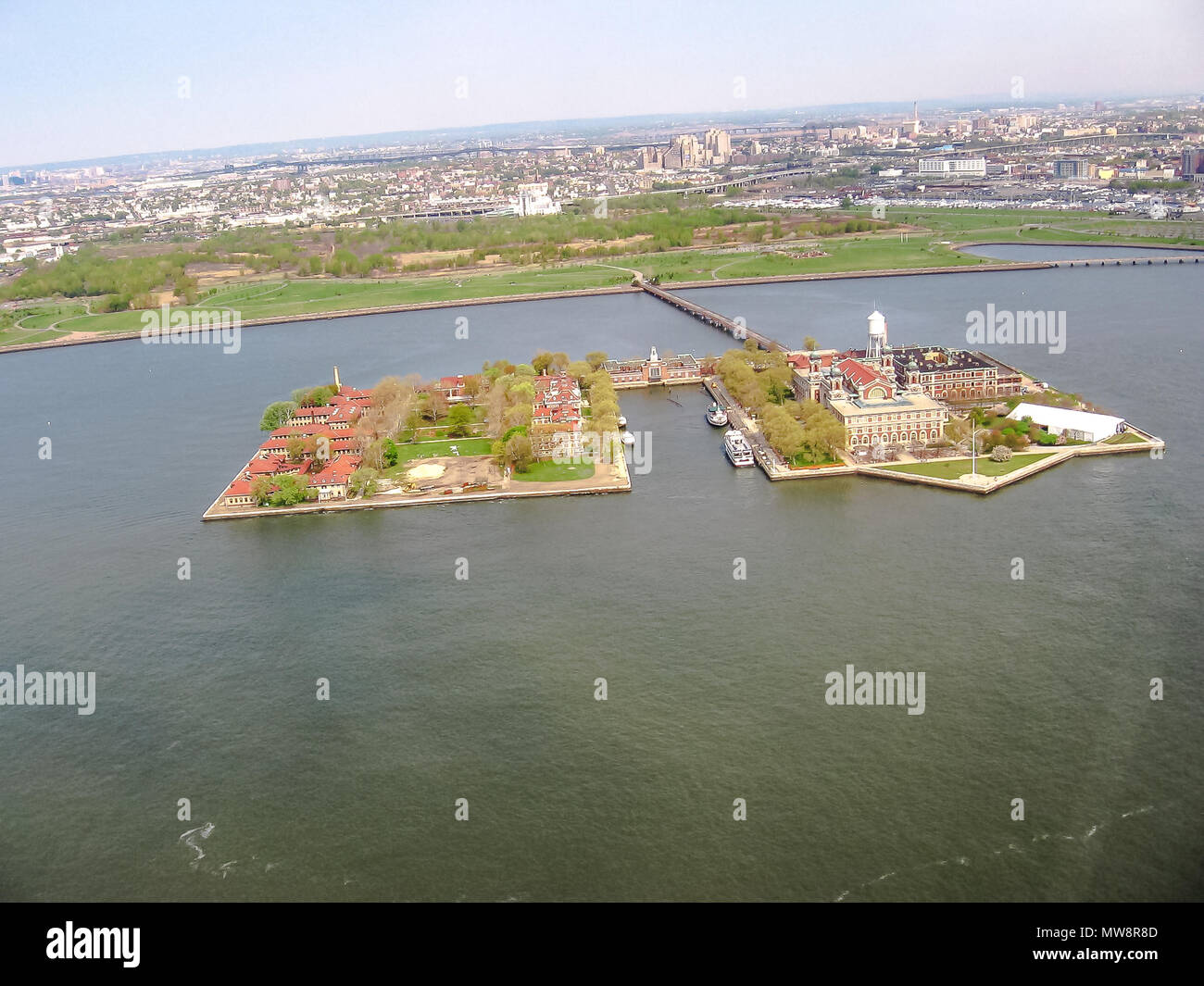 Spektakuläre Helikopterblick auf Ellis Island, eine kleine Insel an der Mündung des Hudson River in New York Harbour, über besucht das gleiche Ticket und Fähre, die Zugang zu den nahe gelegenen Freiheitsstatue ermöglicht. Stockfoto