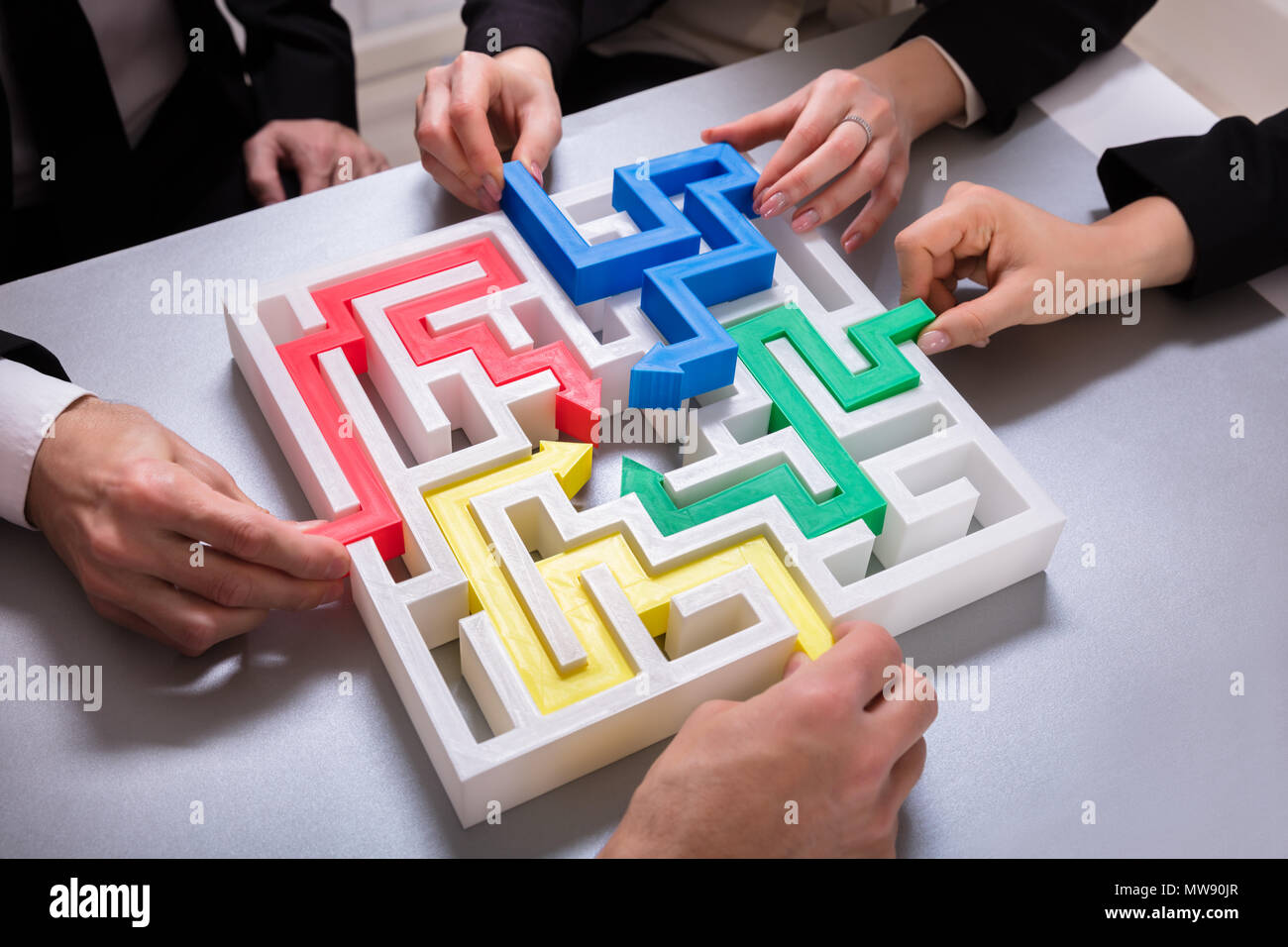 Erhöhten Blick auf Geschäftsleute Hand Lösung Labyrinth Puzzle auf dem Schreibtisch im Büro Stockfoto