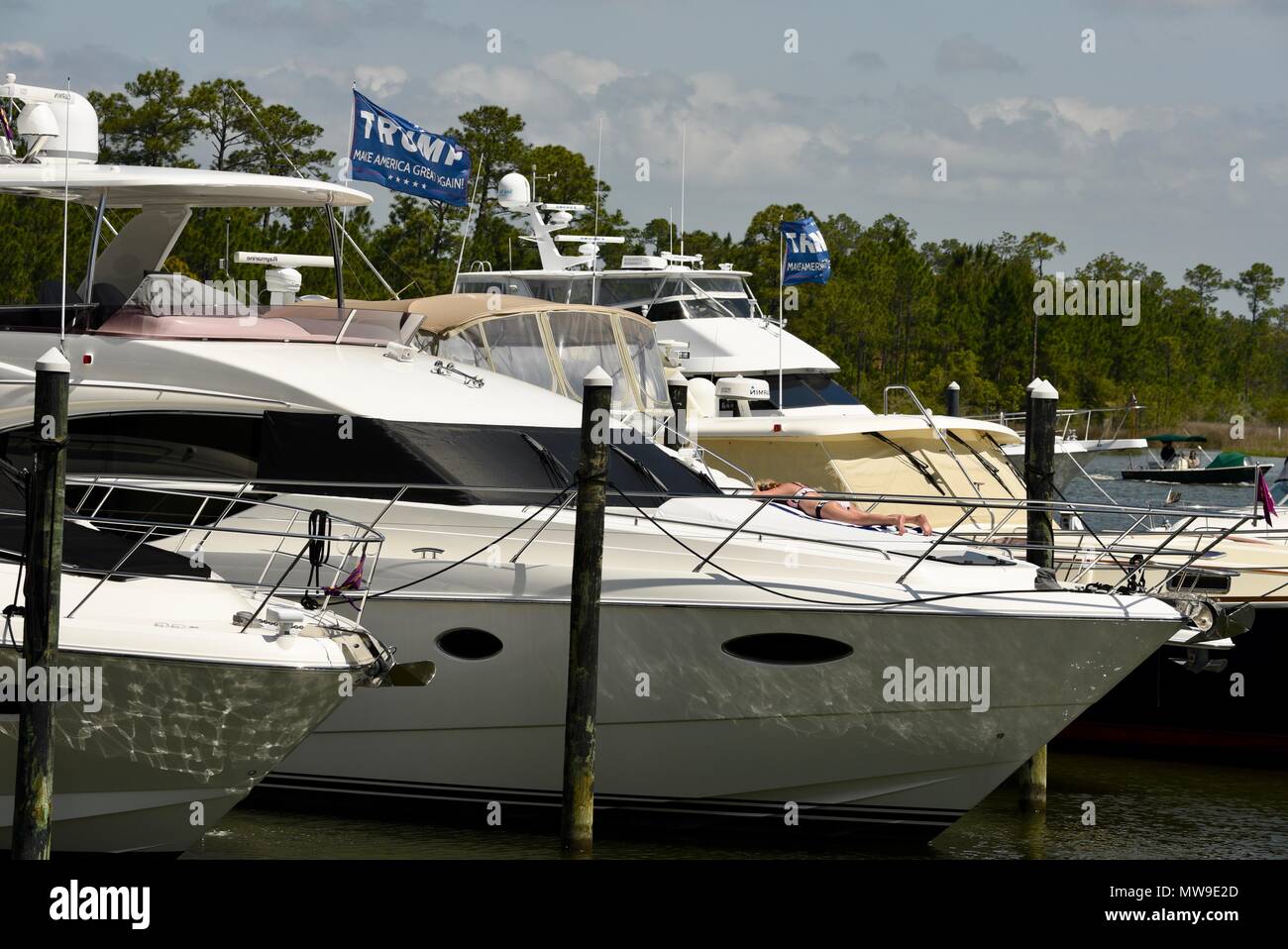 Präsident Donald Trump 'Make Amerika wieder einmal Super' Fahnen flattern im Wind über teure Yachten in der Marina auf der Orange Beach, Alabama, USA gebunden. Stockfoto