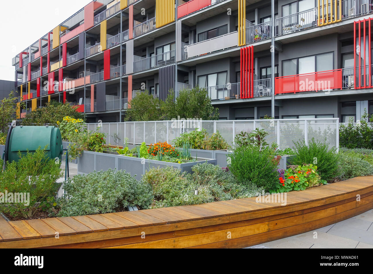 Öffentlicher Garten an der Vorderseite des Wohnapartmentblock. Grüne shared Komposteimer auf der linken Seite. Footscray Plaza, VIC Australien. Stockfoto