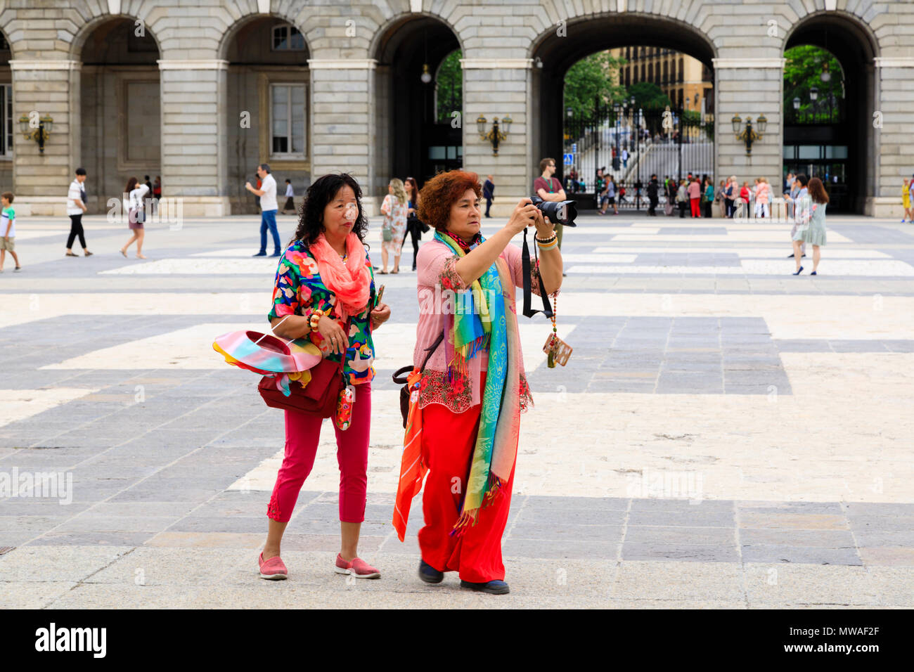 Bunte, reife Chinesische Touristinnen Fotos bei den Königspalast Palacio Real de Madrid nehmen. offizielle Residenz der spanischen Königsfamilie. Ca Stockfoto