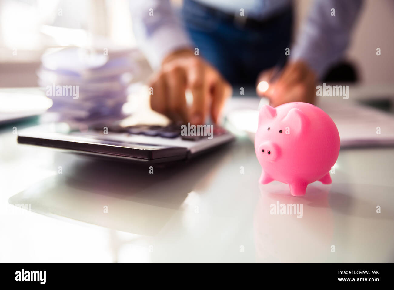 In der Nähe von rosa Sparschwein in der Nähe der Unternehmer Hand mit Taschenrechner Stockfoto