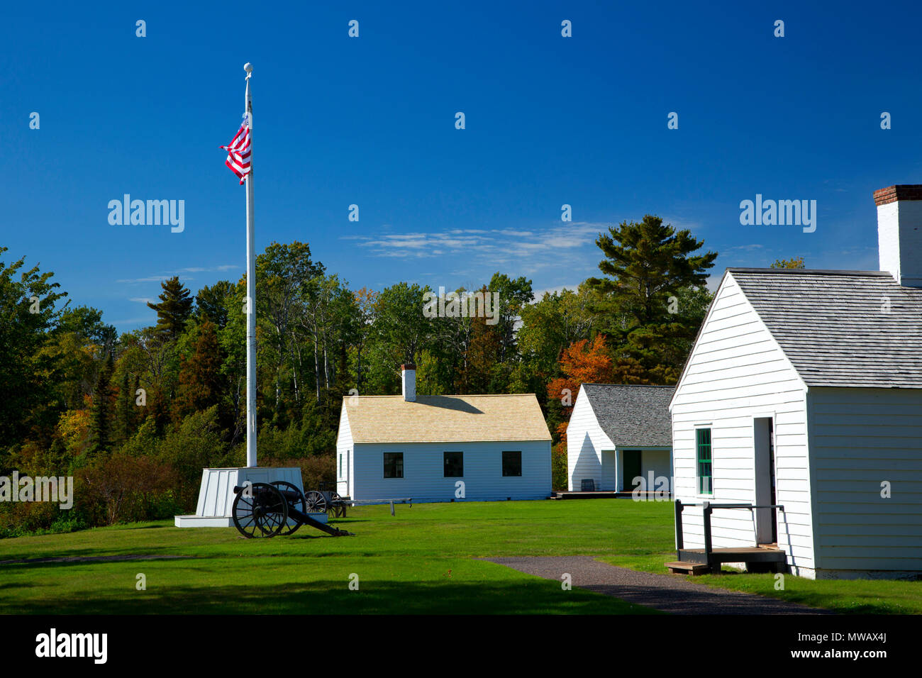 Fahnenmast und Kanone durch Küche und Mess Hall, Fort Wilkins Historic State Park, Michigan Stockfoto