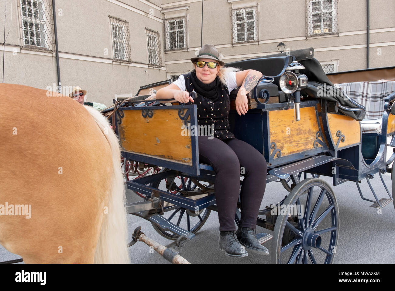 Ein ungelernter Arbeiter Reinigung der Fläche, die sich durch die Fahrten mit der Pferdekutsche für Touristen in Salzburg, Österreich. Stockfoto