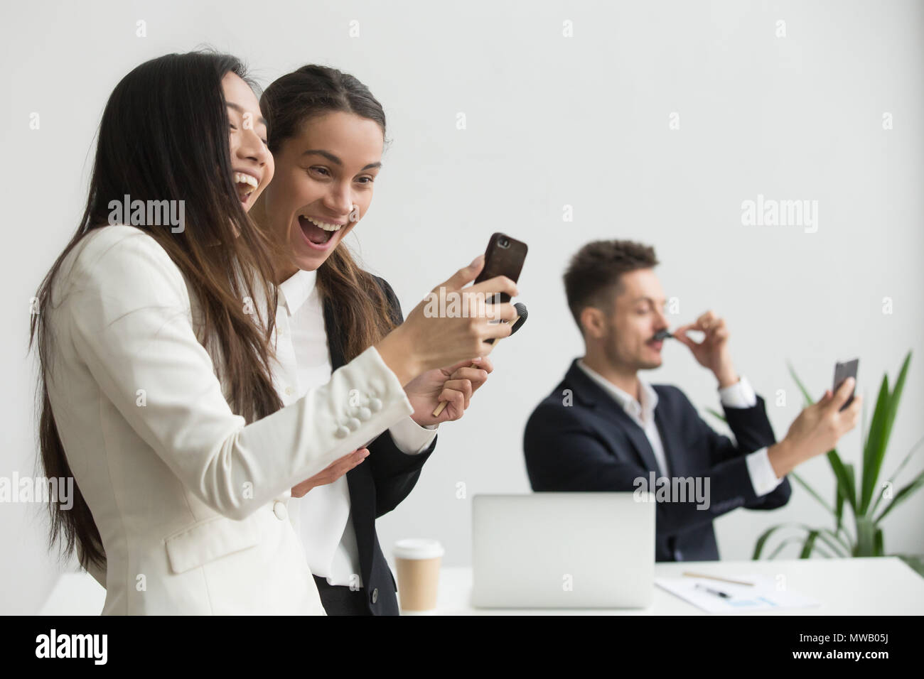 Diverse weiblichen Kollegen lachen Spaß mit Smartphone Stockfoto