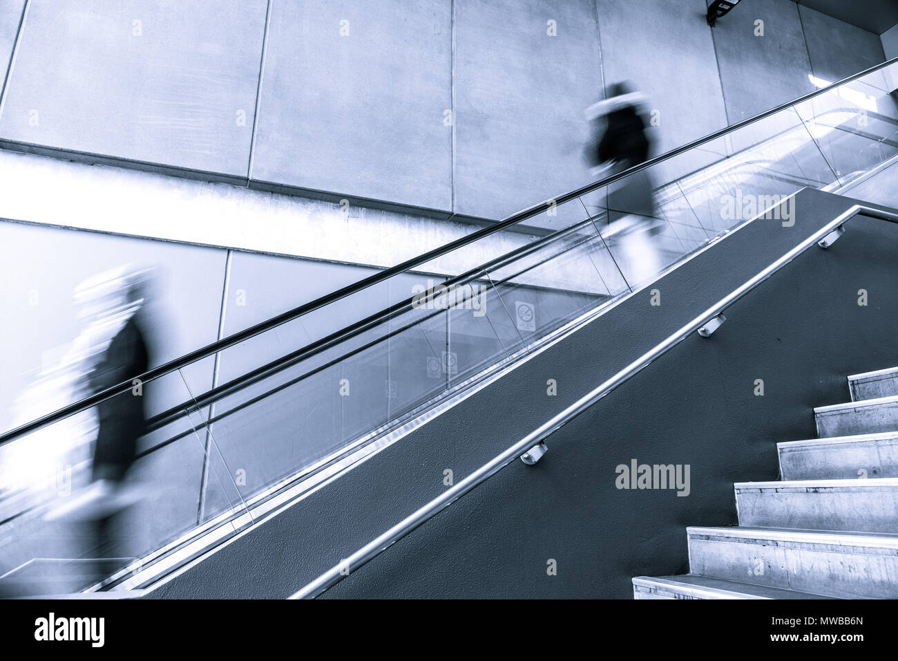 Verschwommene Bewegung von Menschen auf einer Rolltreppe Stockfoto