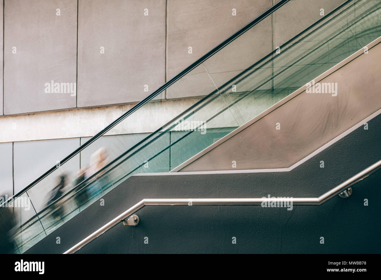 Verschwommene Bewegung der Menschen auf der Rolltreppe mit Copy space-getonten Bild Stockfoto