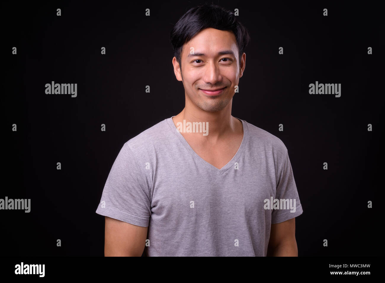 Die Jungen gut aussehenden asiatischer Mann auf schwarzem Hintergrund Stockfoto