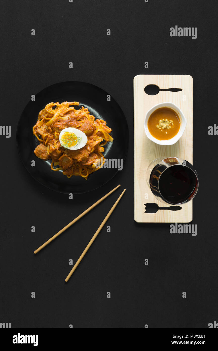 Asiatische spaghetti Nudeln. Ansicht von oben flach auf schwarzem Hintergrund. Stockfoto