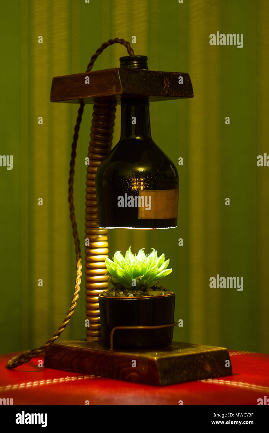 Leuchte handmade-stand für Blumentopf im Vintage Style, Holz, Kupfer Beschläge, LED-Lampe auf einem schwarzen Hintergrund. Stockfoto