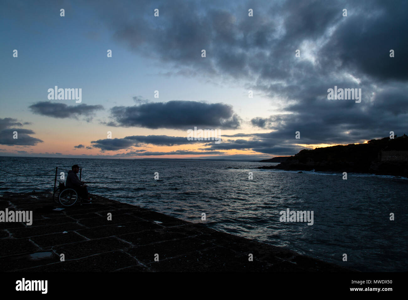 Cornwall, UK. 1. Juni 2018. Cornwall, UK. 1. Juni 2018. Ein Mann im Rollstuhl, die Fischerei Ende des Wellenbrechers, am frühen Abend, in Camborne, Cornwall. Bild: Rob Carter/Alamy Live News: Rob Carter/Alamy leben Nachrichten Stockfoto