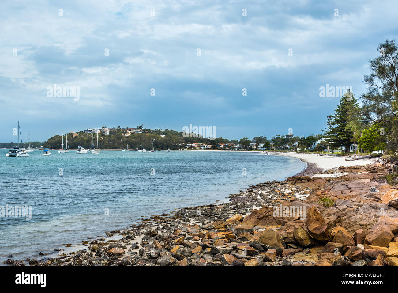 Anzeigen von Salamander Bay, NSW, Australien, mit Steinen in den Vordergrund und Yachten im Hafen. Stockfoto