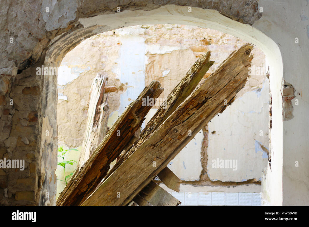 Ein gekauftes Strahl in einem alten, verlassenen Gebäude. Loch in der alten zerstörten Mauer. Sonnenlicht eindringen in den Ruinen einer mittelalterlichen Burg aufgegeben. Stockfoto