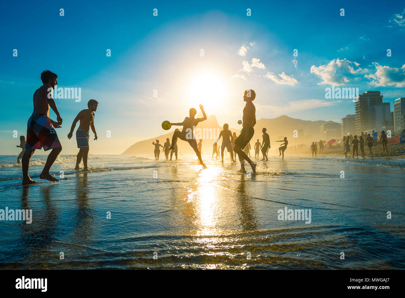 Sonnenuntergang in der Ferne Silhouetten spielen keepy - Uppie Strand Fußball an der Küste in Ipanema Beach Rio de Janeiro. Stockfoto