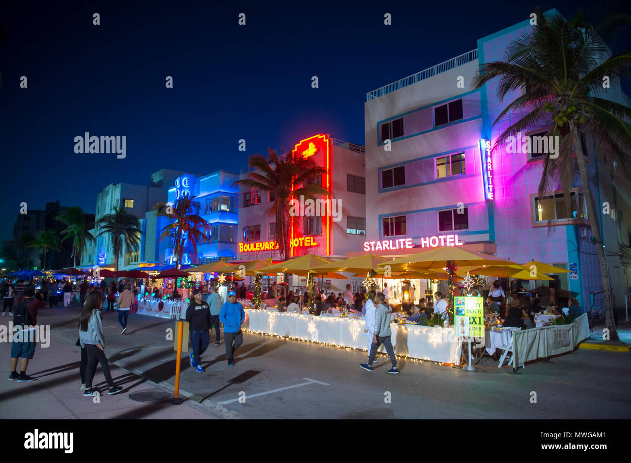 MIAMI - 30. Dezember 2017: Menschen gehen vorbei an berühmten Art déco-Hotels und Leuchtreklamen am Ocean Drive in South Beach bei Nacht. Stockfoto